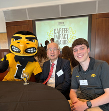 Photo of Dr. Shiu accepting the award for our department and Drew Dupont with Herky.